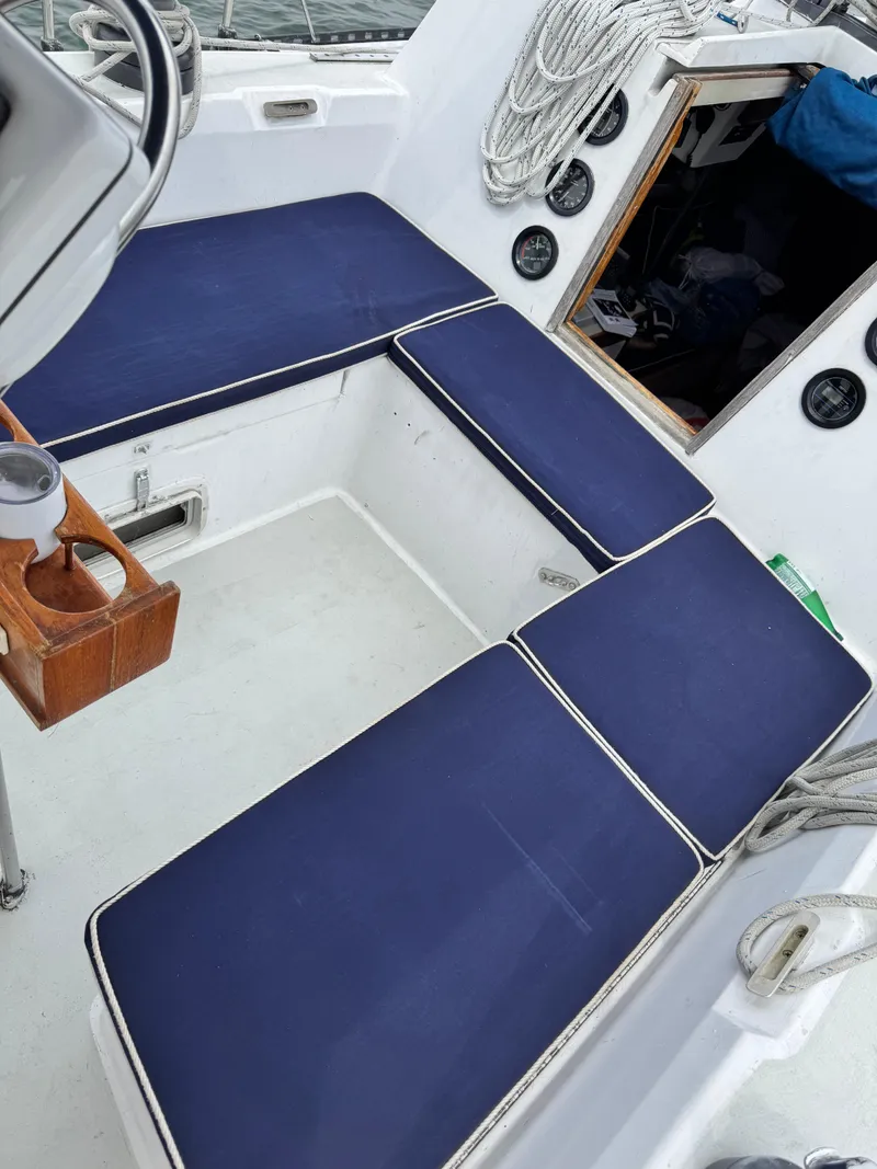 Slide: The Image of Cockpit of 1981 C&C 37 sailboat with blue cushions and nautical equipment. - 10