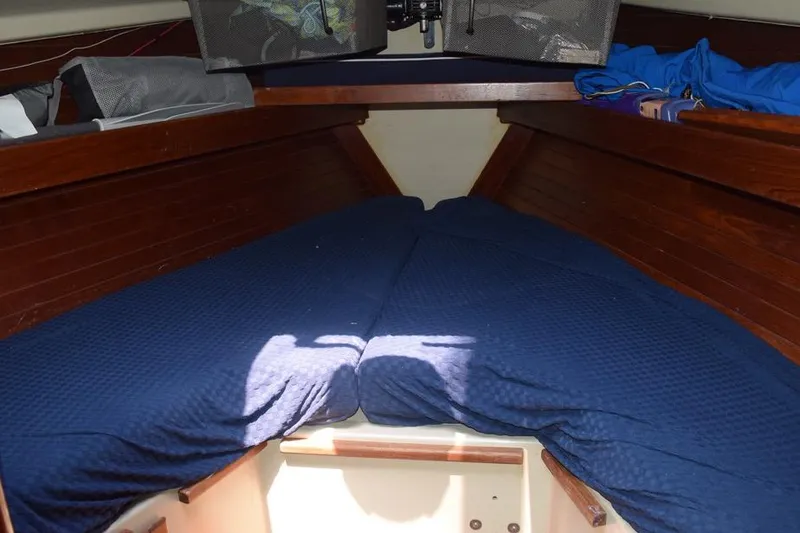 Slide: The Image of Interior cabin of 1981 C&C 37 sailboat with blue bedding and wooden paneling. - 27
