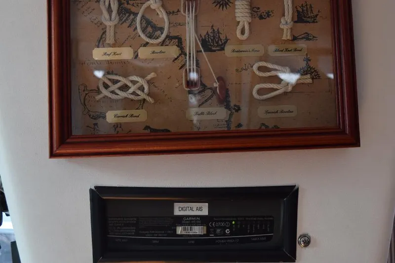 Slide: The Image of Framed nautical knots display above a digital AIS device on a 1981 C&C 37 sailboat. - 35