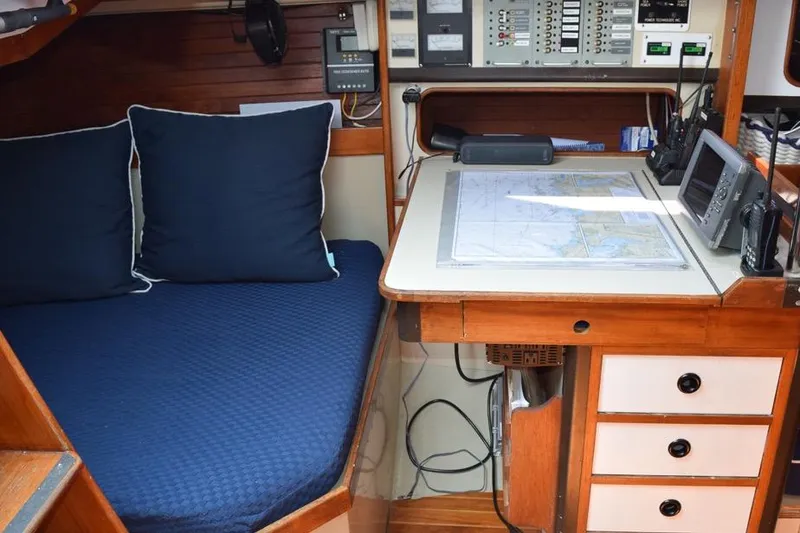 Slide: The Image of 1981 C&C 37 sailboat interior with navigation station and blue cushioned seating. - 47
