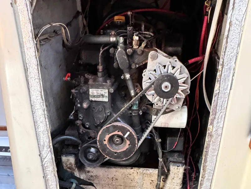 Slide: The Image of Engine compartment of a 1981 C&C 37 sailboat, featuring mechanical components and wiring. - 53