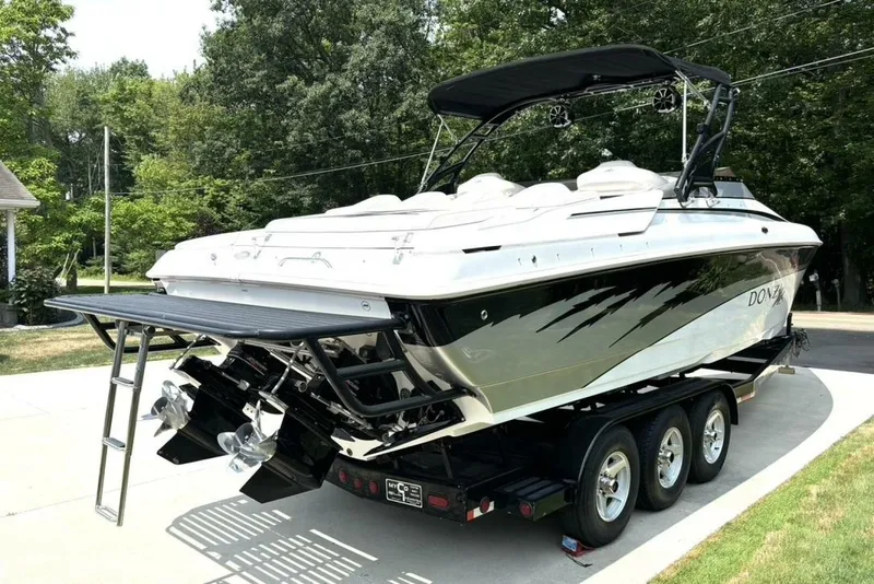 Slide: The Image of 2005 Donzi 33ZX speedboat on trailer, parked outdoors, showcasing sleek design and powerful engines. - 5