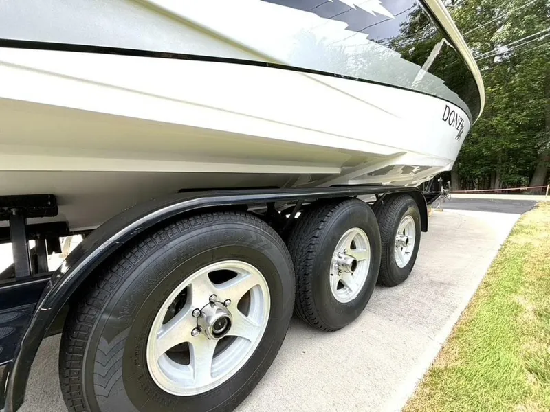 Slide: The Image of 2005 Donzi 33ZX boat on a triple-axle trailer, parked on a driveway. - 10