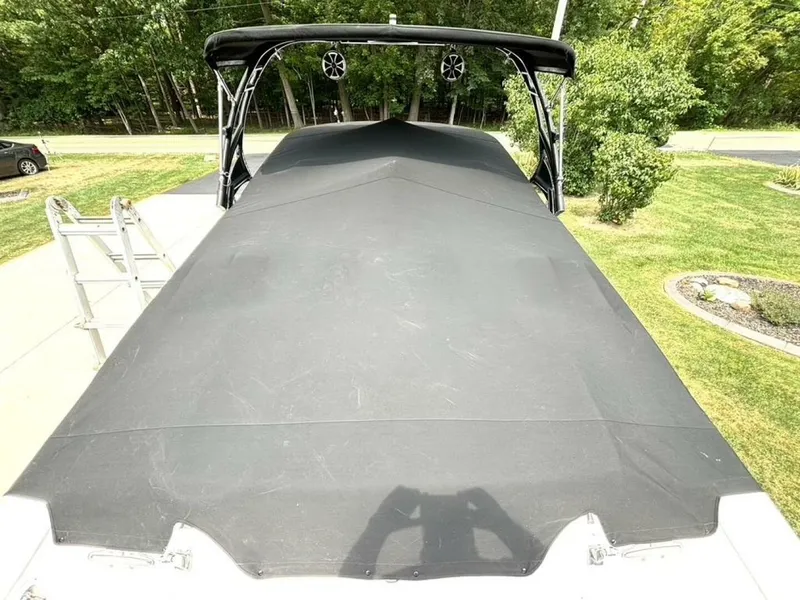 Slide: The Image of 2005 Donzi 33ZX boat with black cover, parked outdoors on a sunny day. - 49