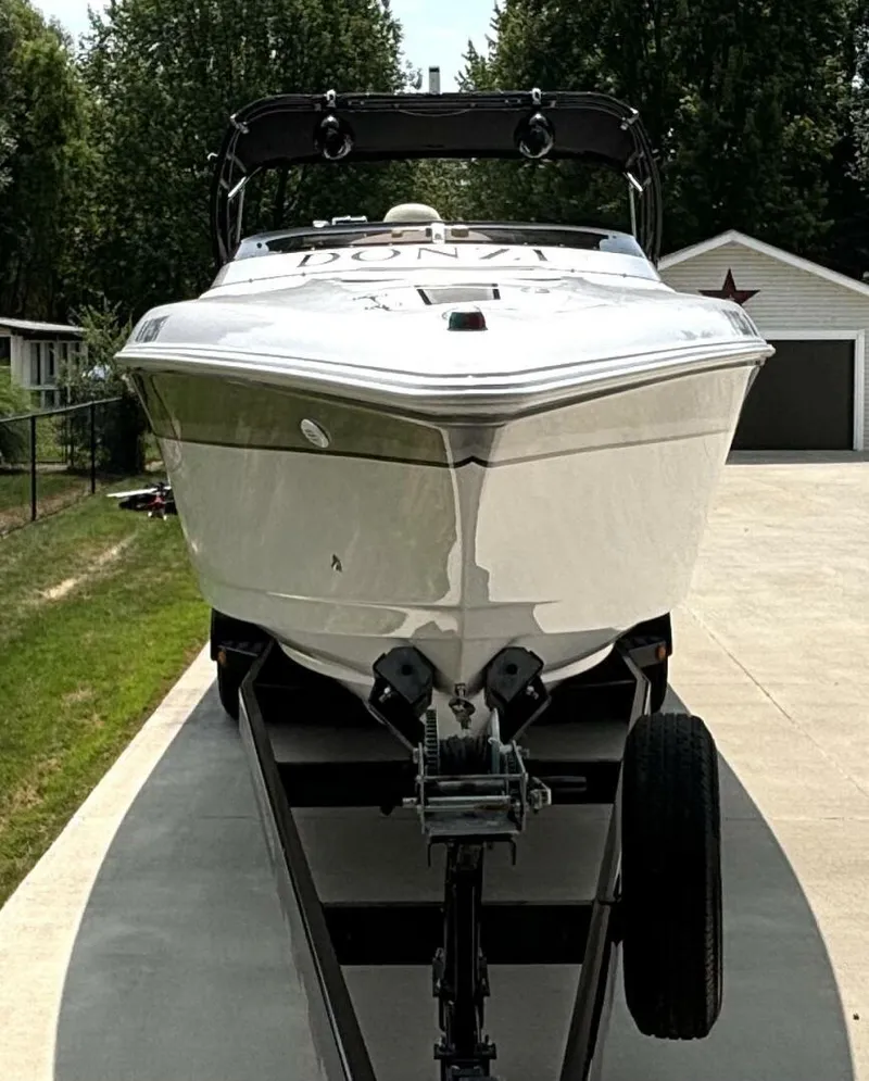 Slide: The Image of 2005 Donzi 33ZX boat on trailer, parked in driveway, surrounded by trees and garage. - 8