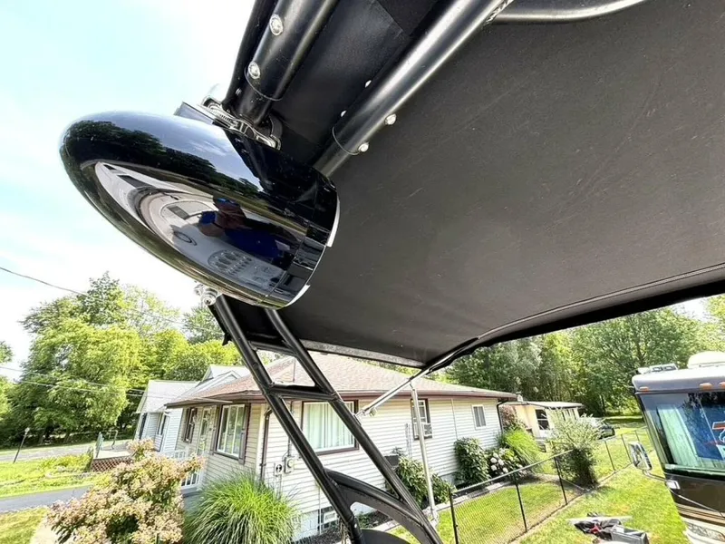 Slide: The Image of 2005 Donzi 33ZX boat with black canopy and sleek design, parked near residential area. - 43