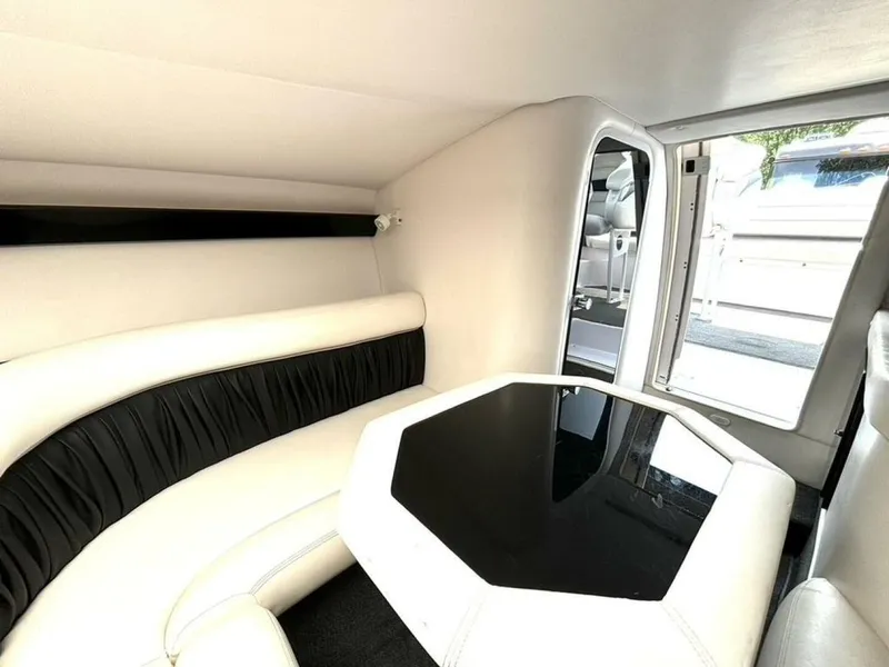 Slide: The Image of Interior of 2005 Donzi 33ZX boat with white seating and black table. - 33