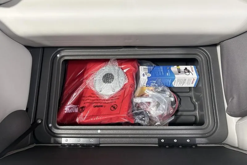 Slide: The Image of Storage compartment in 2026 Sun Tracker Fishin' Barge 20 DLX with safety equipment and accessories. - 22
