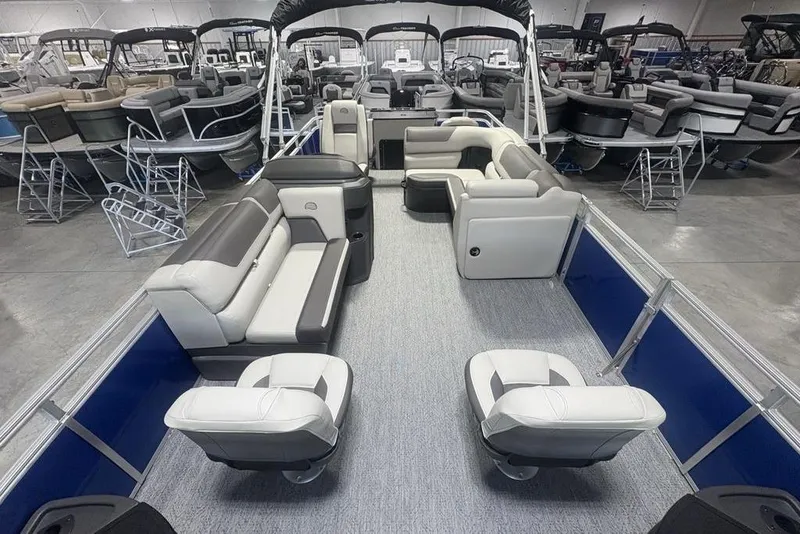 Slide: The Image of 2026 Sun Tracker Fishin' Barge 20 DLX pontoon boat interior with plush seating in showroom. - 31