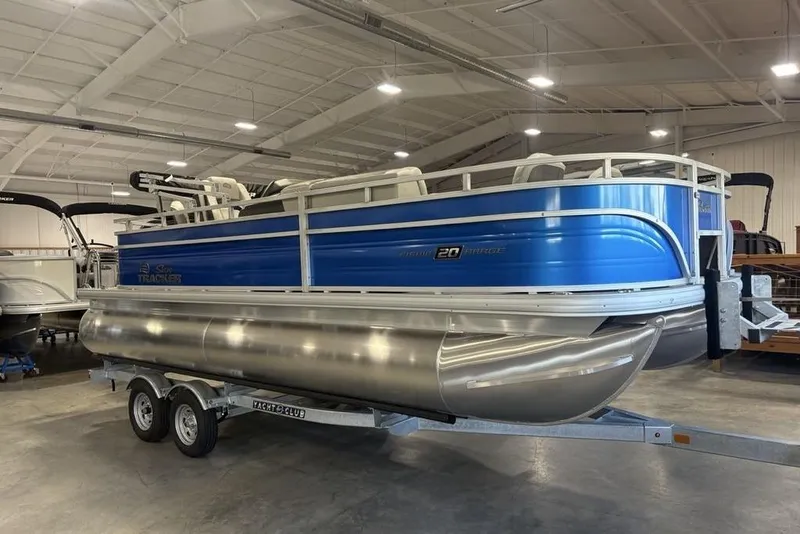 Slide: The Image of 2026 Sun Tracker Fishin' Barge 20 DLX pontoon boat on trailer in indoor showroom. - 4