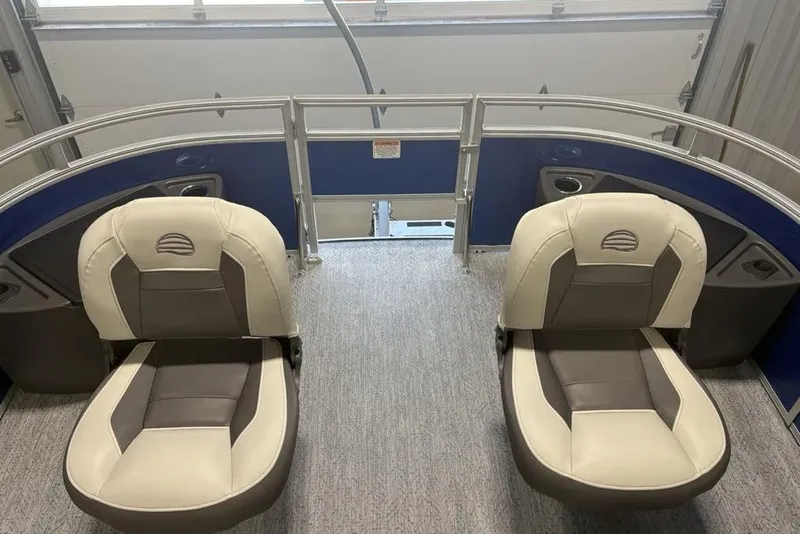 Slide: The Image of 2026 Sun Tracker Fishin' Barge 20 DLX interior with two cushioned seats and blue paneling. - 5