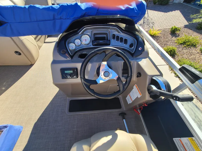 Slide: The Image of 2022 Sun Tracker Party Barge 20 DLX steering console with gauges and controls. - 10