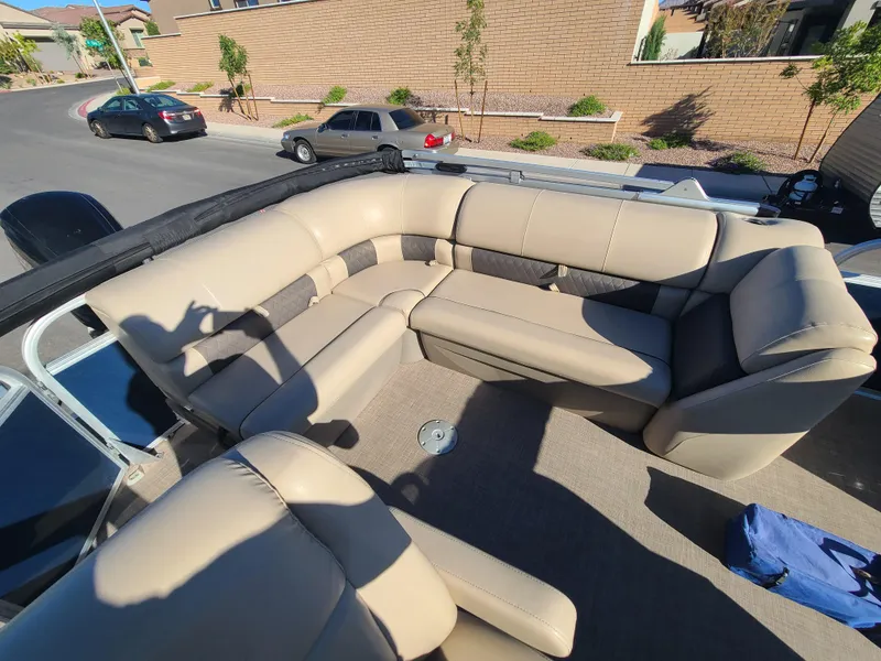 Slide: The Image of 2022 Sun Tracker Party Barge 20 DLX with beige seating on a sunny street. - 11