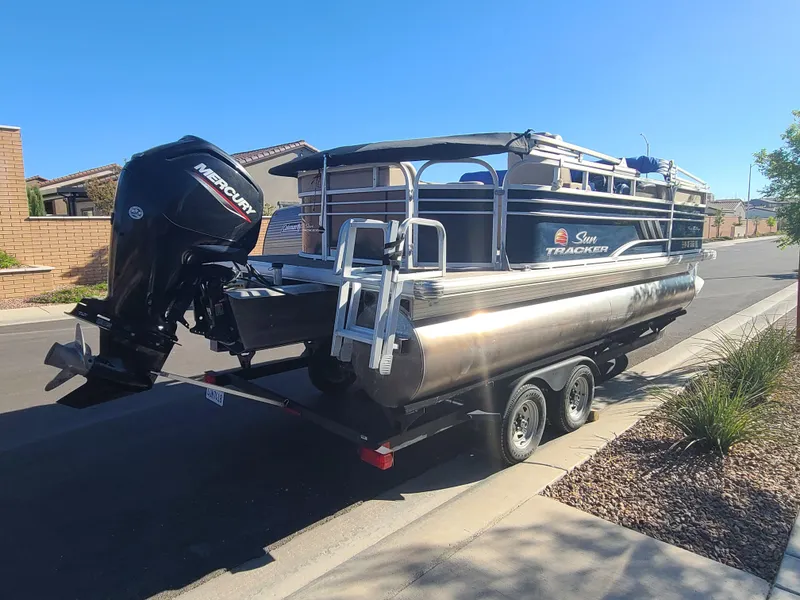 Slide: The Image of 2022 Sun Tracker Party Barge 20 DLX pontoon boat on trailer, parked on street. - 4