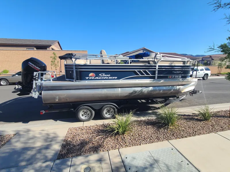 Slide: The Image of 2022 Sun Tracker Party Barge 20 DLX pontoon boat on trailer in residential area. - 5