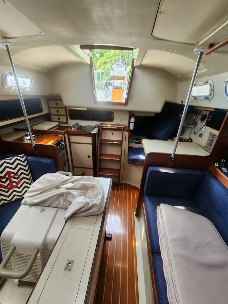 Slide: The Image of Interior of a 1982 C&C 34 sailboat with wood flooring and compact kitchen. - 11