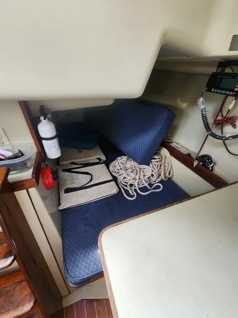 Slide: The Image of Interior of 1982 C&C 34 sailboat with ropes, fire extinguisher, and blue cushions. - 18