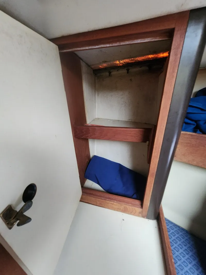 Slide: The Image of Interior storage compartment of a 1982 C&C 34 sailboat with wooden trim. - 25