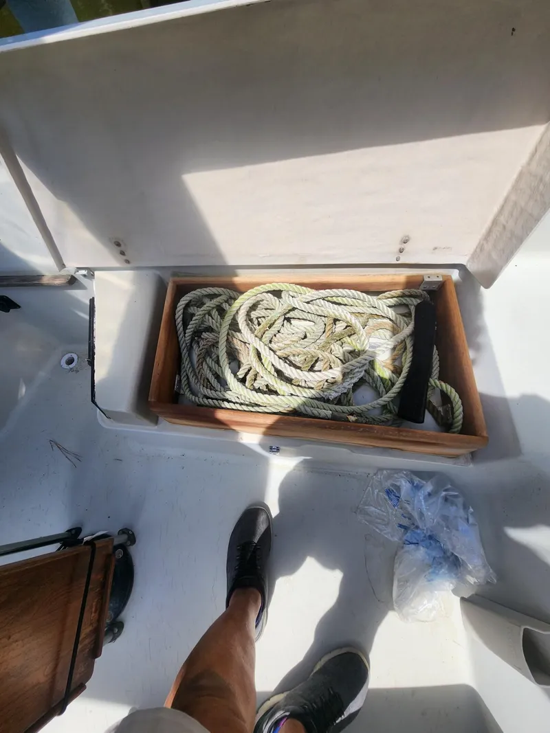 Slide: The Image of Open storage compartment on 1982 C&C 34 sailboat with coiled rope inside. - 27