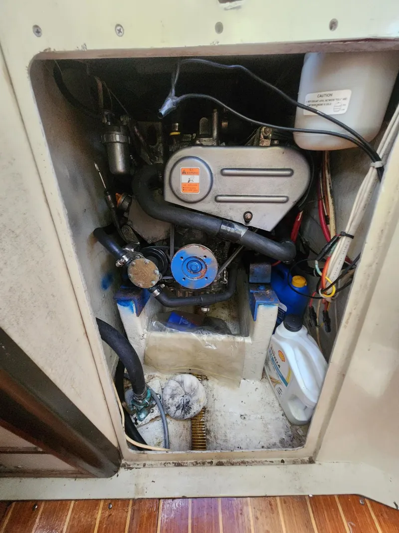 Slide: The Image of Engine compartment of a 1982 C&C 34 sailboat, showing mechanical components and maintenance supplies. - 29