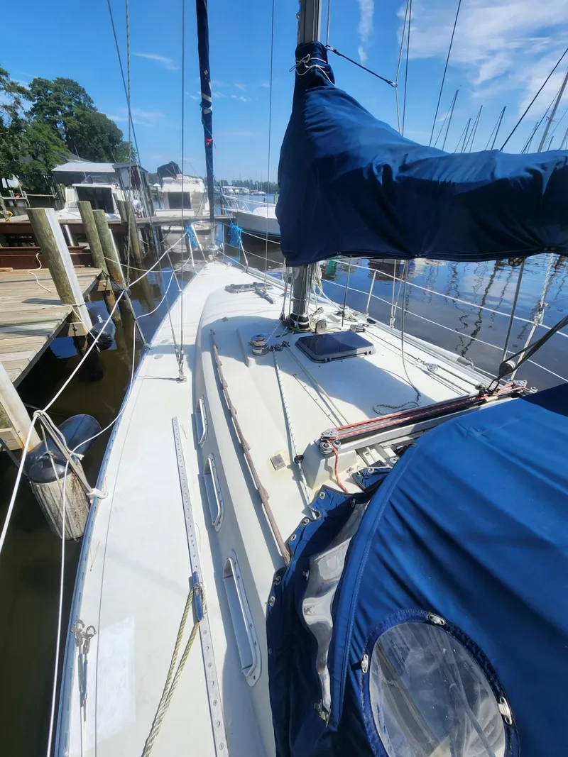 Slide: The Image of 1982 C&C 34 sailboat docked, featuring blue sail covers and a clean deck. - 5
