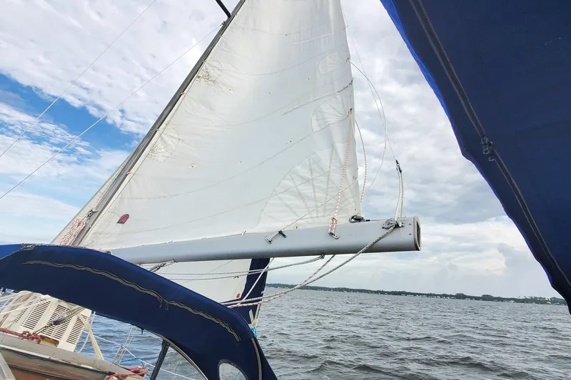 Slide: The Image of Sailing on a 1982 C&C 34 yacht with white sails against a cloudy sky. - 9