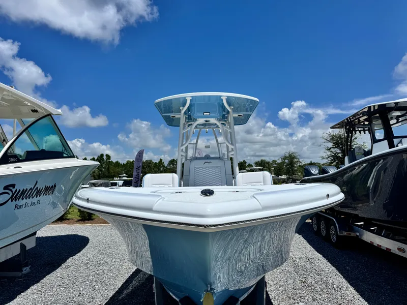 Slide: The Image of 2026 Yellowfin 26 Hybrid boat with Mercury engine on trailer, parked outdoors. - 3
