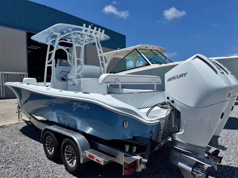 Slide: The Image of 2026 Yellowfin 26 Hybrid boat on trailer, blue hull, clear sky background. - 6