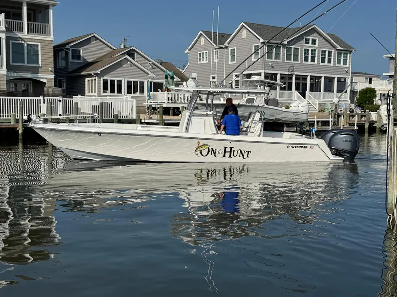 The Image of 2022 Contender 32 ST boat docked near waterfront homes, featuring Yamaha engines. - 0