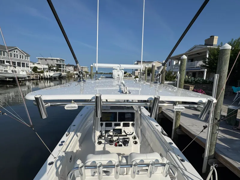 Slide: The Image of 2022 Contender 32 ST boat docked, showcasing helm and fishing rod holders. - 15