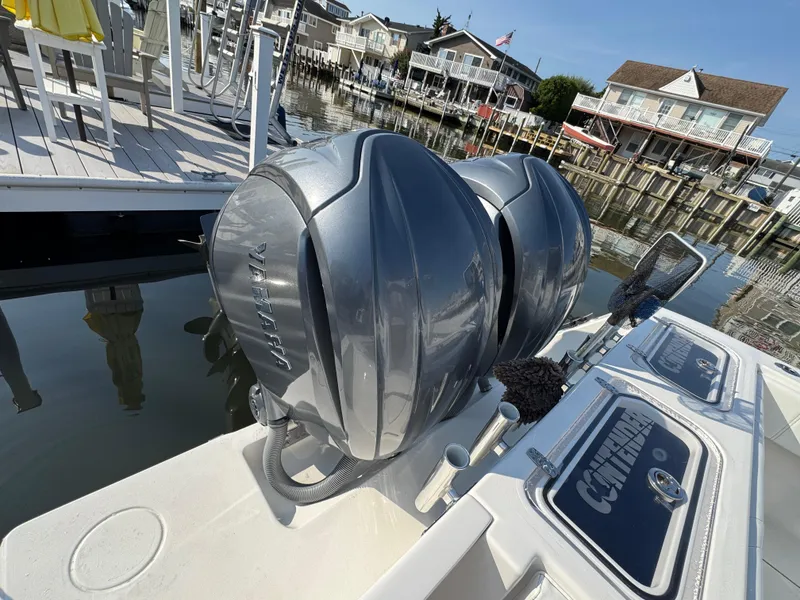 Slide: The Image of 2022 Contender 32 ST boat with dual Yamaha outboard engines docked by waterfront homes. - 16