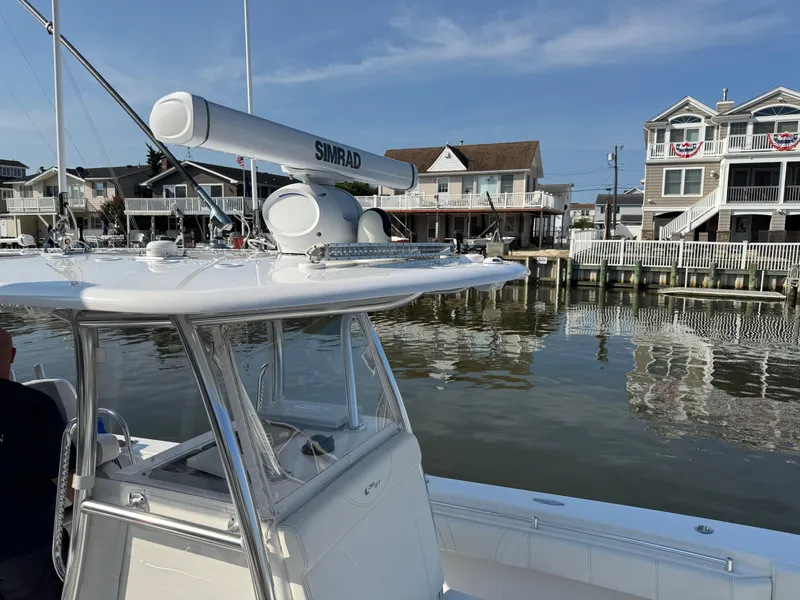 Slide: The Image of 2022 Contender 32 ST boat docked near waterfront homes, featuring Simrad radar. - 26