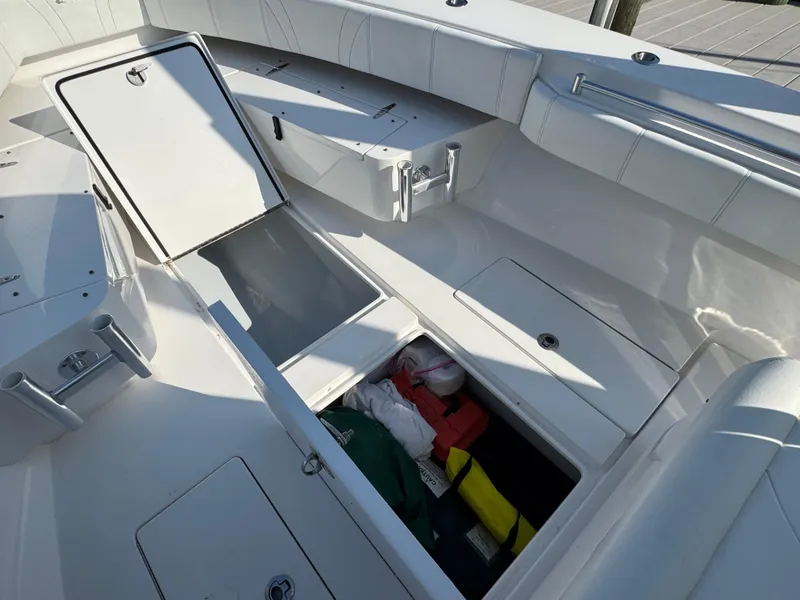 Slide: The Image of 2022 Contender 32 ST boat with open storage compartments and visible gear. - 28