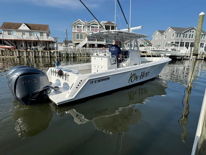 Slide: The Image of 2022 Contender 32 ST boat docked, featuring Yamaha engines, in a residential marina setting. - 8