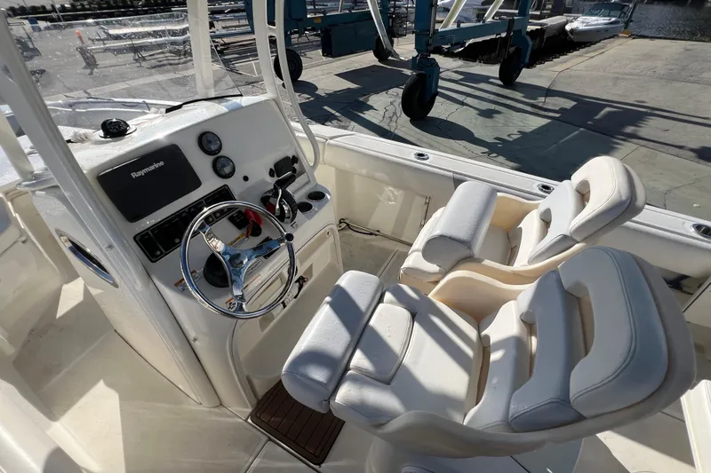 Slide: The Image of 2015 Boston Whaler 220 Outrage boat cockpit with steering wheel and dual seats. - 17