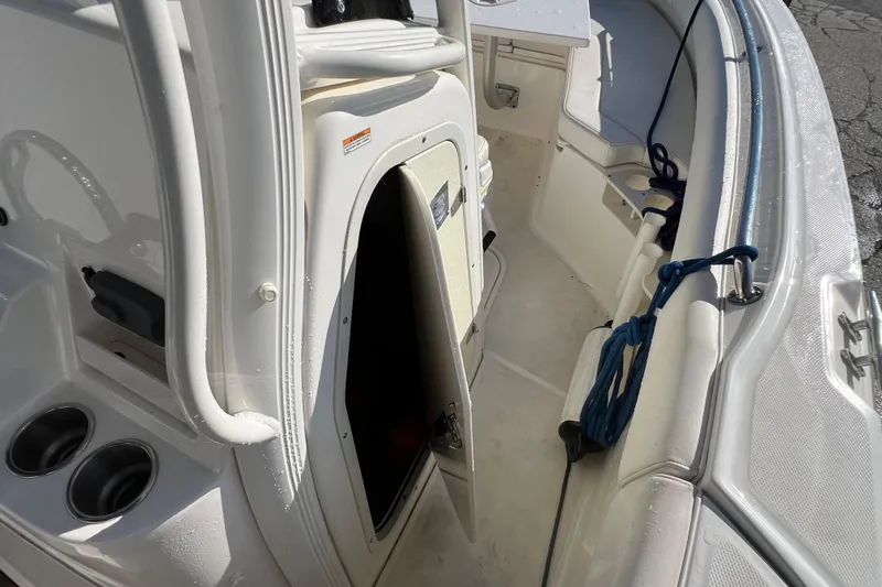 Slide: The Image of 2015 Boston Whaler 220 Outrage interior with open storage compartment and seating area. - 21