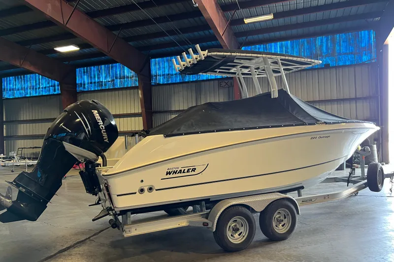 Slide: The Image of 2015 Boston Whaler 220 Outrage boat with Mercury engine in a warehouse. - 26