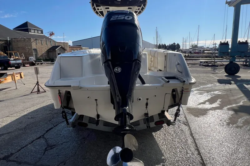 Slide: The Image of 2015 Boston Whaler 220 Outrage boat with powerful 250 HP engine, docked outdoors. - 6