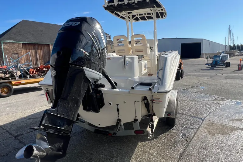 Slide: The Image of 2015 Boston Whaler 220 Outrage boat with powerful Mercury engine, parked outdoors. - 7