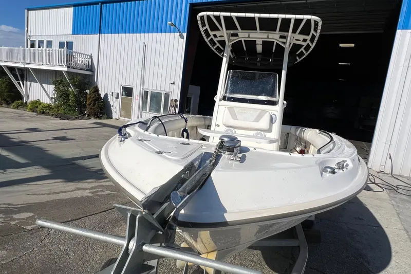 Slide: The Image of 2015 Boston Whaler 220 Outrage boat outside a blue and white building. - 9