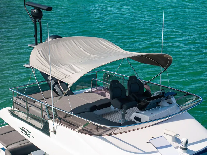 Slide: The Image of 2021 Azimut S6 yacht with canopy, featuring sleek design and luxurious seating on turquoise water. - 2