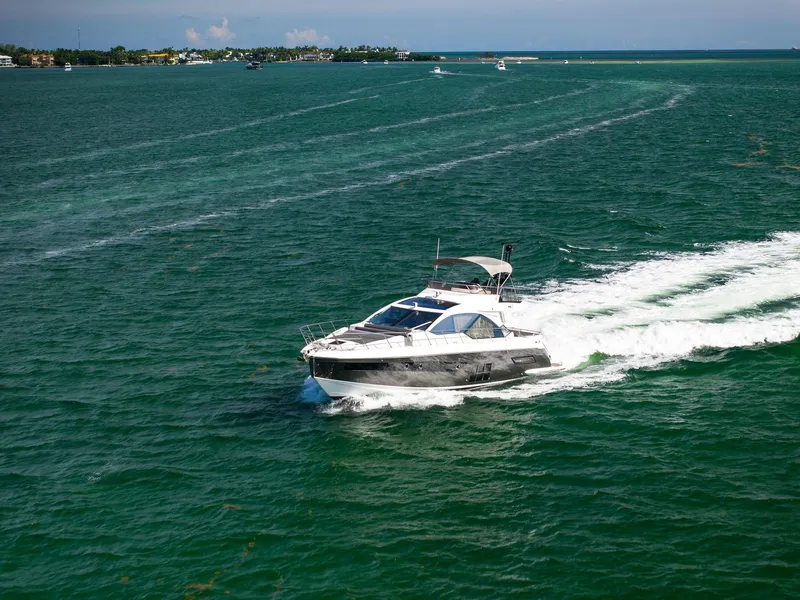 Slide: The Image of 2021 Azimut S6 yacht cruising on open water, leaving a trail of white waves. - 47
