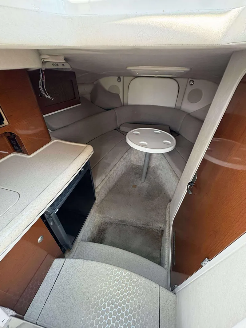 Slide: The Image of 2008 Sea Ray 290 SLX cabin interior with seating, table, and kitchenette. - 13