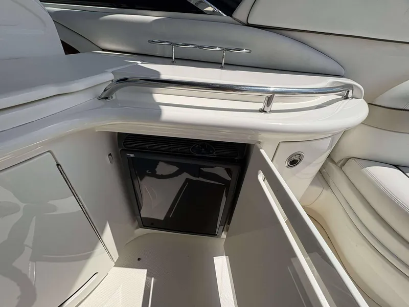 Slide: The Image of Interior of a 2008 Sea Ray 290 SLX boat featuring a mini fridge and sleek white design. - 9