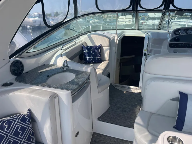 Slide: The Image of 2007 Chaparral 330 Signature boat interior with seating, sink, and nautical-themed pillows. - 15