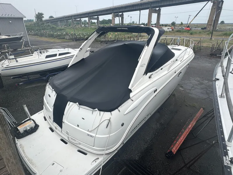 Slide: The Image of 2007 Chaparral 330 Signature boat covered, docked near a bridge. - 2