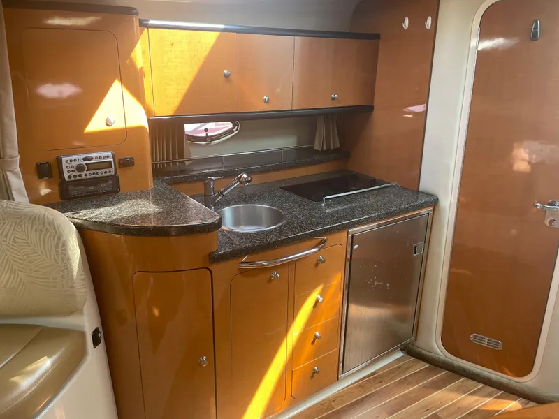 Slide: The Image of 2007 Chaparral 330 Signature yacht interior kitchen with wooden cabinets and stainless steel appliances. - 29