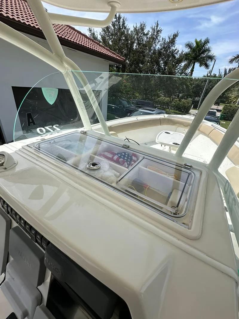 Slide: The Image of 2018 Sailfish 270 CC boat interior with beige seating and steering console. - 14