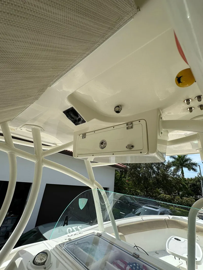 Slide: The Image of 2018 Sailfish 270 CC boat interior with dual engines, near a house and garden. - 15