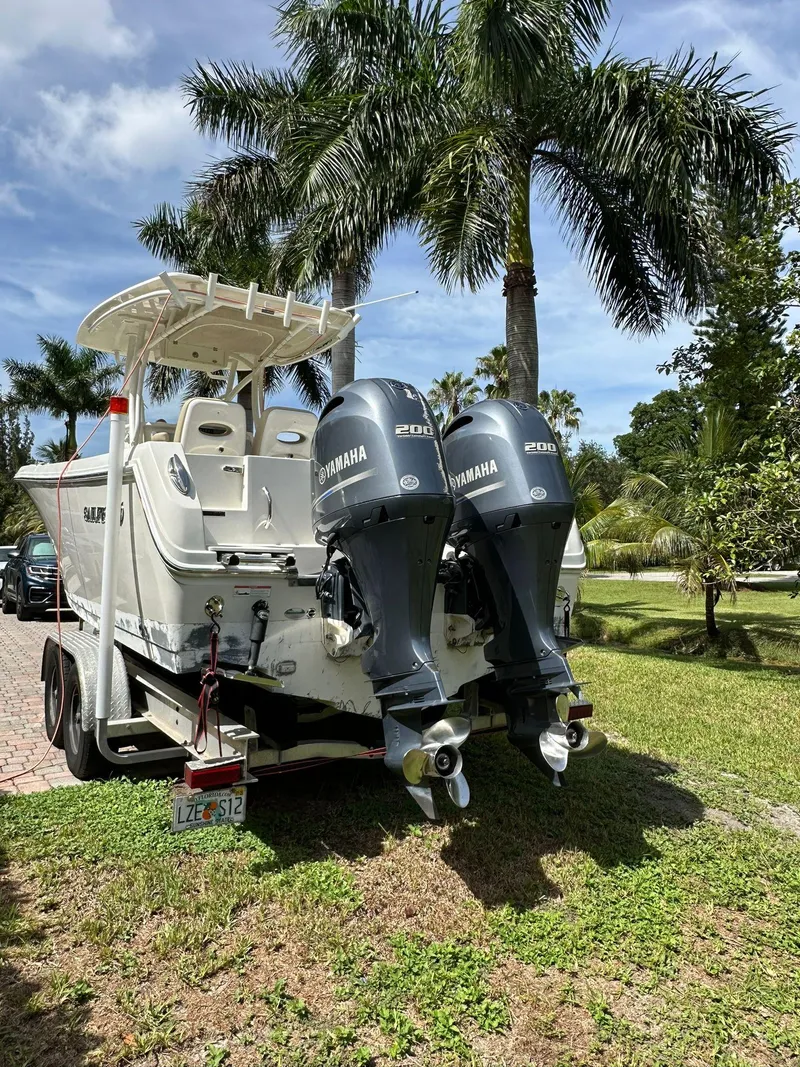 Slide: The Image of 2018 Sailfish 270 CC boat on trailer, side view, parked on grass. - 2